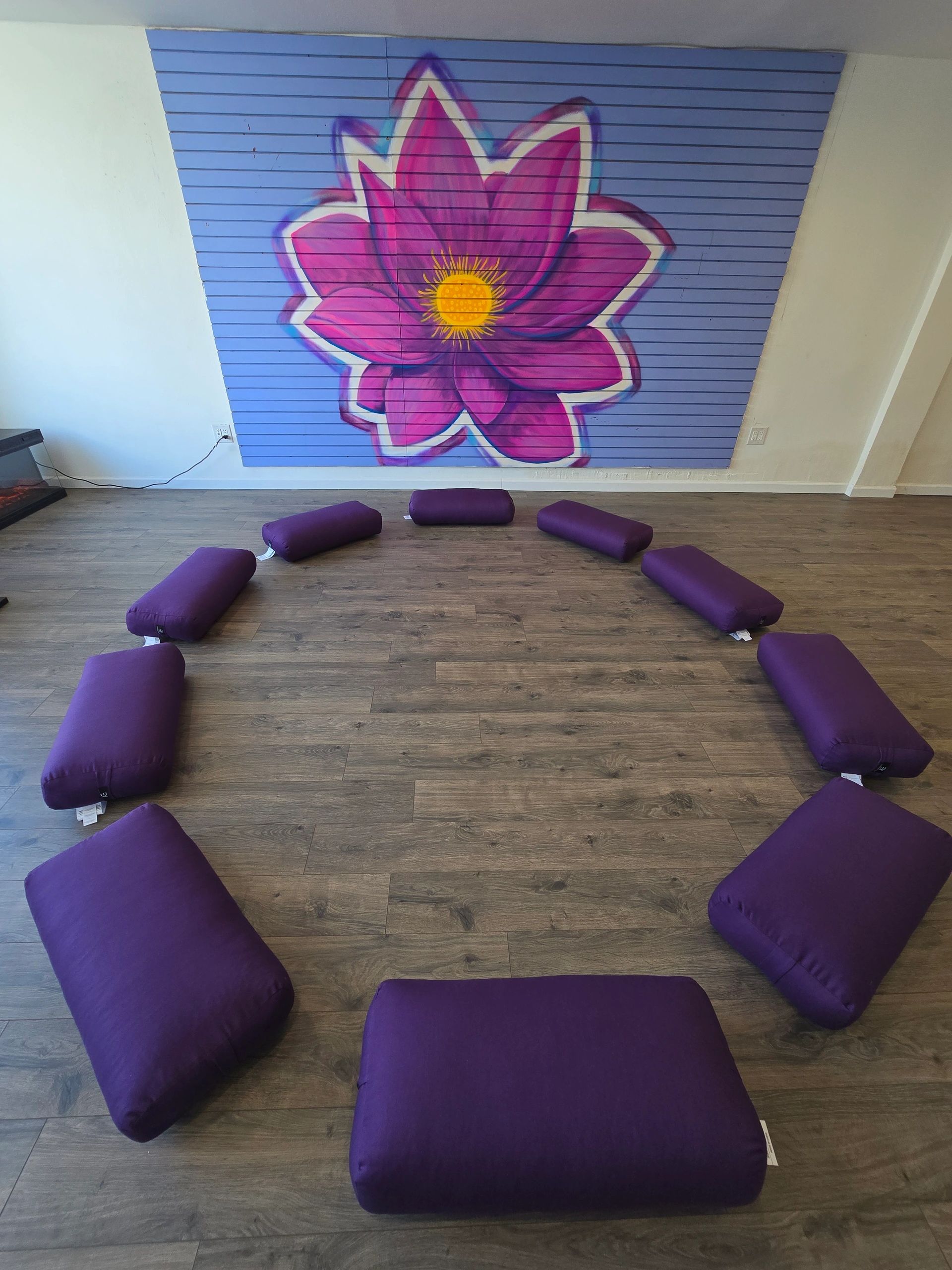 Purple bolsters arranged around the Lotus mural inside the studio
